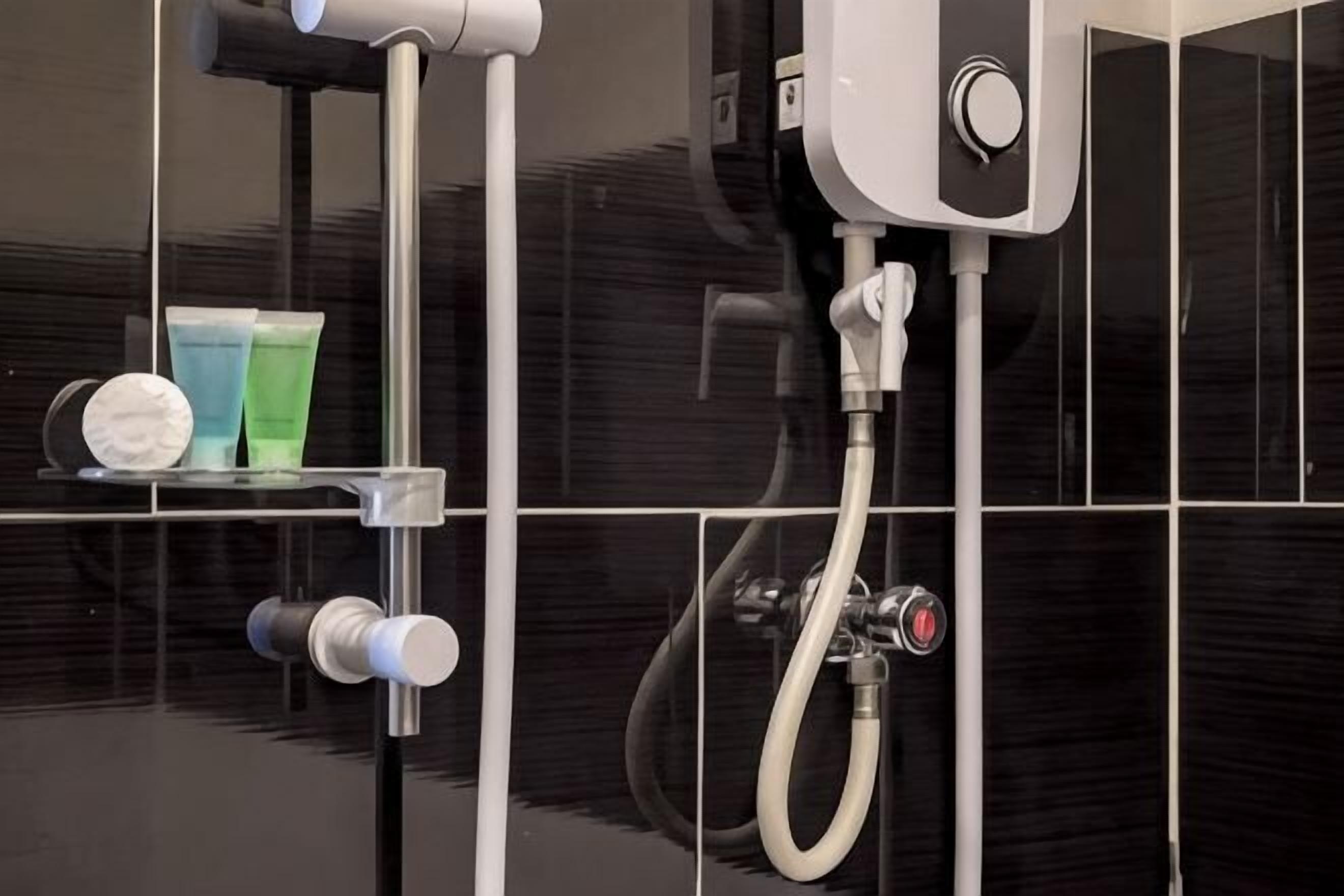 A bathroom with a shower, a towel rack, and a shelf with toiletries.