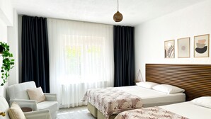 A hotel room with a bed, a chair, a hanging plant, and a window with curtains. - Şahan Apart (Yesilova)