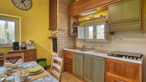 Una cocina con armarios de madera, pared de ladrillo, un lavamanos y una estufa.