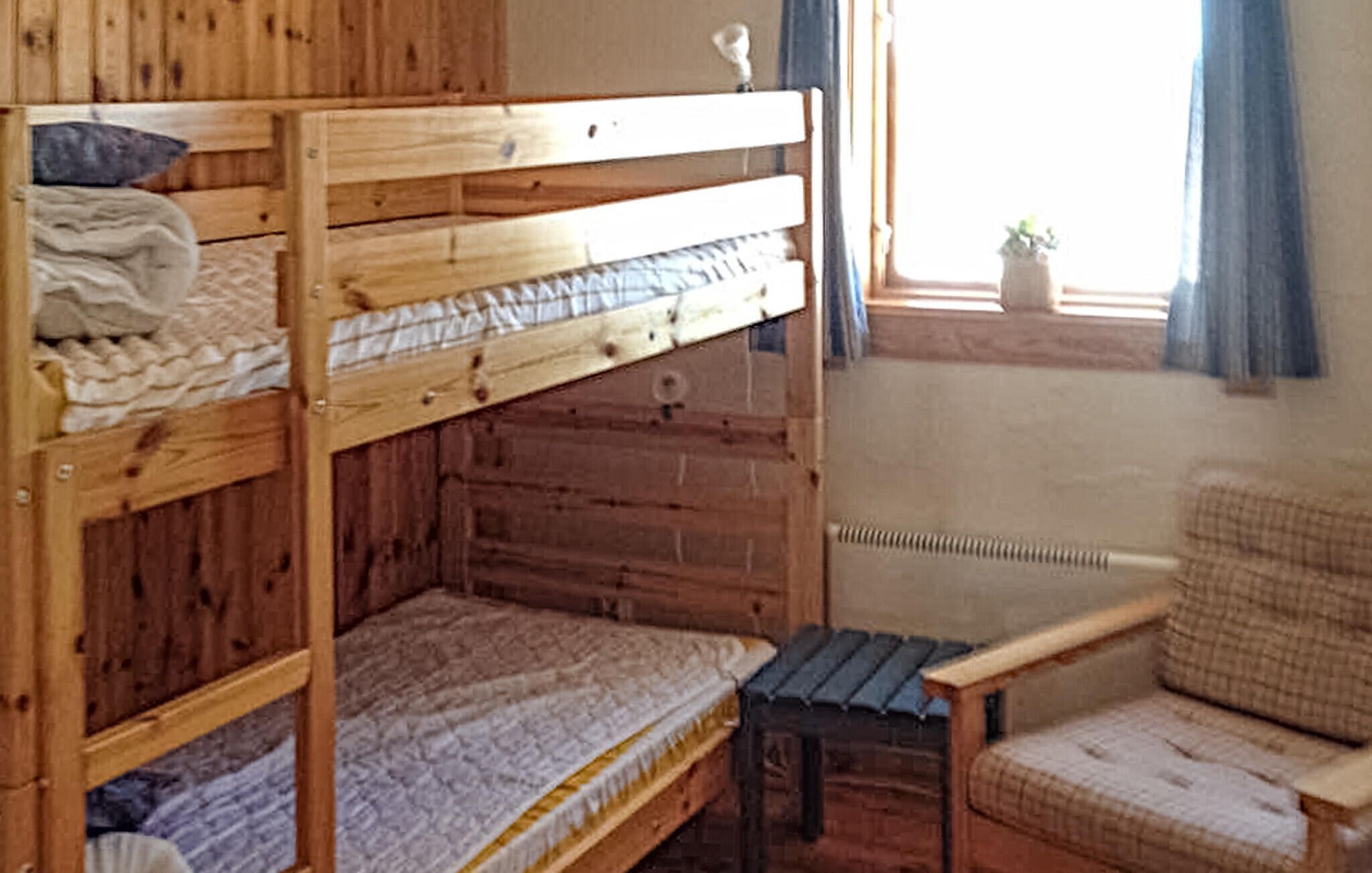 A bunk bed room with a small table and a chair.