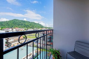 Un balcón con vista a un paisaje urbano y una colina.