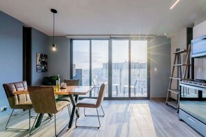 Une cuisine moderne dotée d’un four encastré et d’un coin repas avec une table et des chaises.