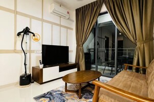Una sala de estar moderna con una televisión de pantalla plana, un aspirador, un sofá y una mesa de comedor.