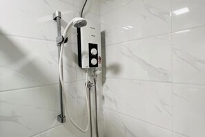 A modern bathroom with a shower unit, a control panel, and a handheld showerhead. - Gelang Patah Forest City-Ataraxia Park 3 (Gelang Patah)