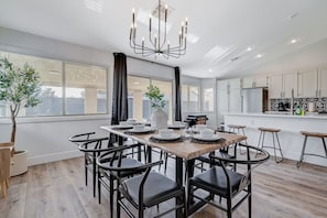 Une cuisine moderne avec des armoires blanches, un comptoir noir et un luminaire suspendu.