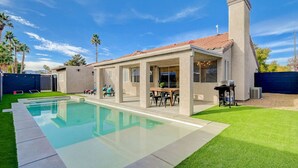 Une maison moderne dotée d’une piscine, d’un patio avec mobilier d’extérieur et d’une pelouse bien entretenue.