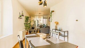A dining area with a wooden table, chairs, and hanging pendant lights. There is a potted plant and a basket on the table. - ★ T2 Cathedral & Torre Ventosa ★ Centre ★ Clim ★ Wifi ★ Parking on request (Béziers)
