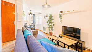 A modern living room with a sofa, TV, and dining area. - ★ T2 Cathedral & Torre Ventosa ★ Centre ★ Clim ★ Wifi ★ Parking on request (Béziers)