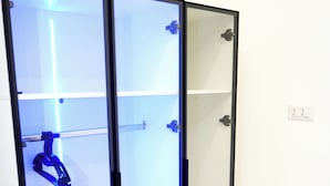 A room with a glass-fronted cabinet with multiple shelves and a blue hanging object. - Lifestyle Naples B&B (Naples)