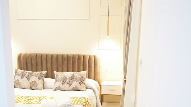 A hotel room with a bed, bedside table, and a lamp. - Lifestyle Naples B&B (Naples)