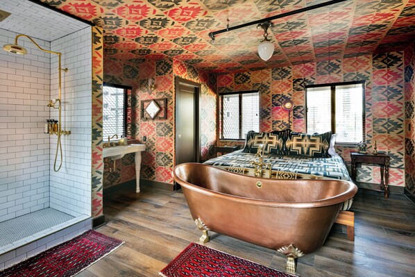 A bathroom with a freestanding bathtub, a shower, and a patterned ceiling. - Urban Cowboy Denver (Denver)