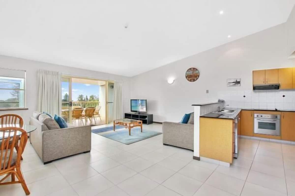 A modern apartment with a living area, dining space, and kitchen.