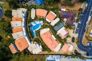 An aerial view of a resort with multiple buildings, a swimming pool, and a tennis court. - Lennox Beach Resort (Lennox Head)