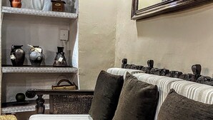 A cozy living room with a sofa, a coffee table, and shelves with decorative items. - CAN PINÓS DE GUIMERÀ  (Guimerà)