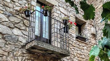Un bâtiment en pierre doté d’un balcon, d’une porte et d’une fenêtre.