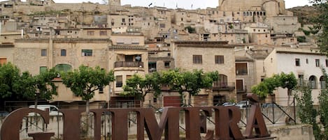 A historic town with stone buildings, a prominent sign reading "GUIMERA," and a mix of residential and commercial structures.