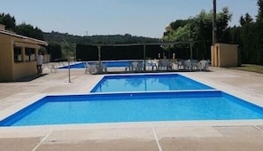 A rectangular swimming pool with a tiled deck surrounding it. - CAN PINÓS DE GUIMERÀ (Guimerà)
