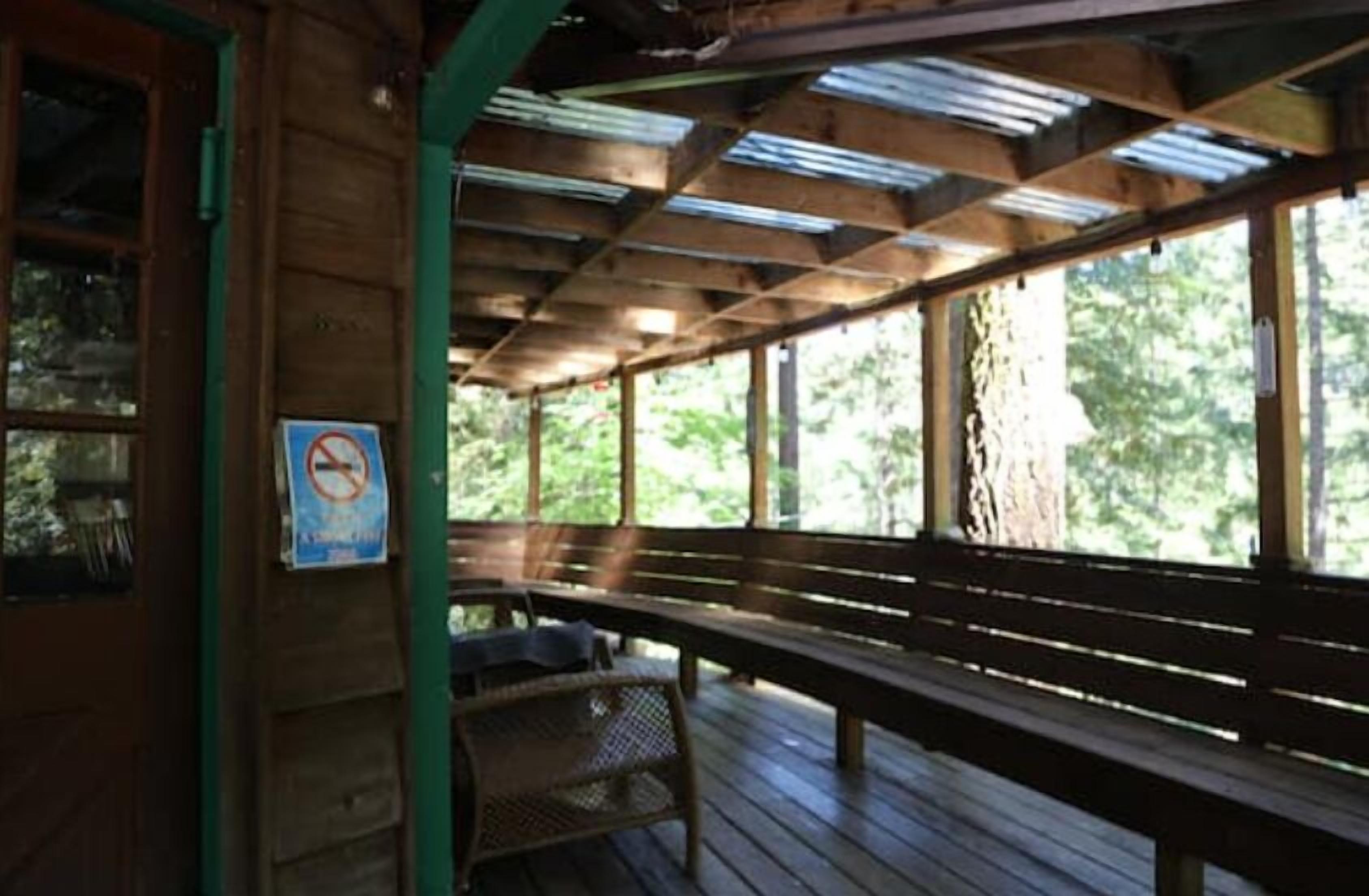 An outdoor wooden deck with benches and a no-smoking sign.