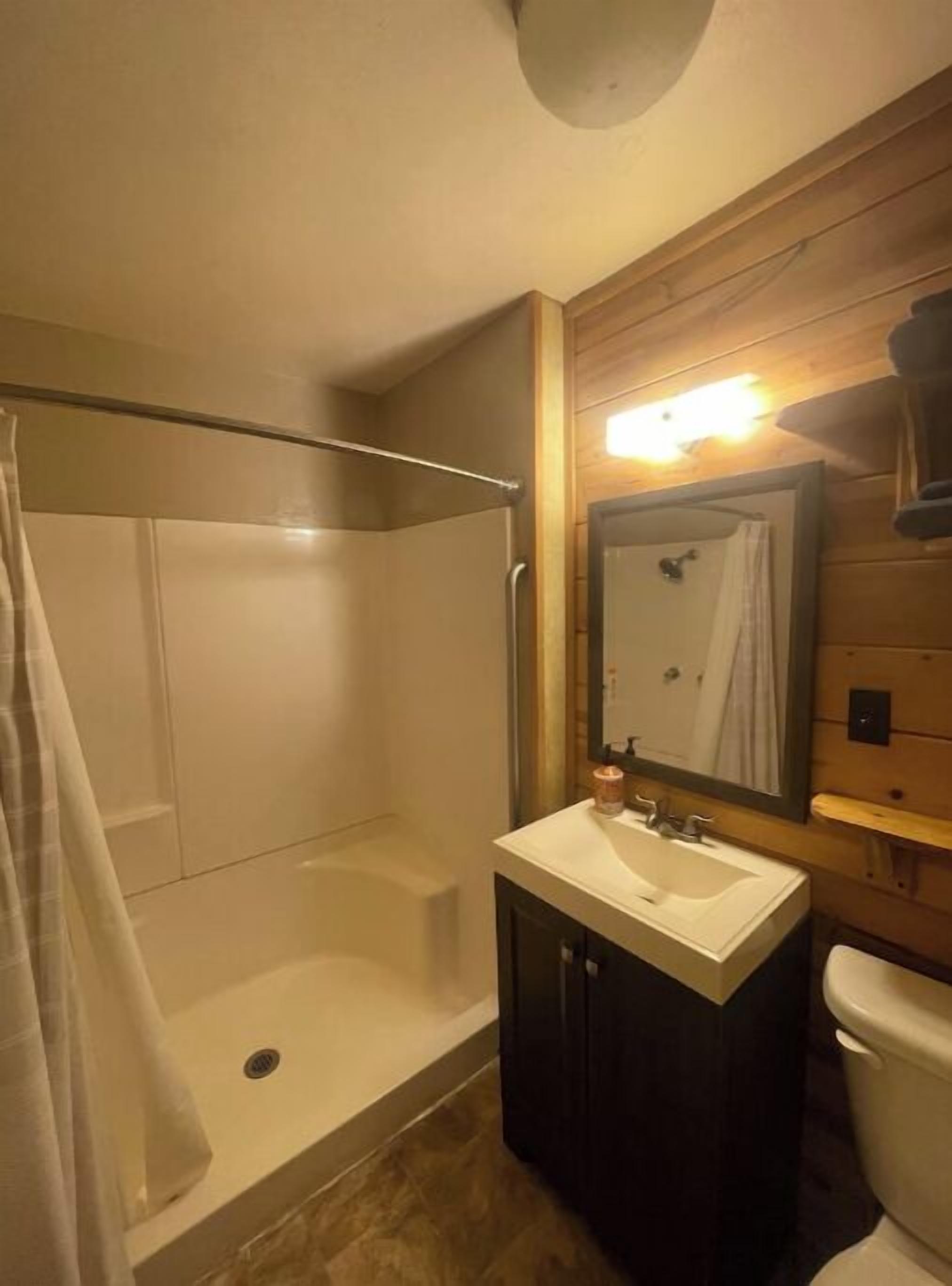 Une salle de bain avec une douche, un lavabo et des toilettes.