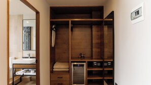 Une salle de bain moderne avec un meuble-lavabo en bois, une douche intégrée et un petit réfrigérateur.