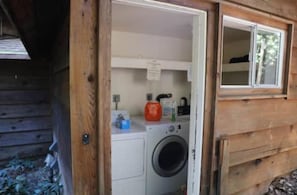 A laundry area with a washing machine and a drying rack. - "Madrone" Cabin In the Redwoods, River Access, WiFi 

 (Garberville)