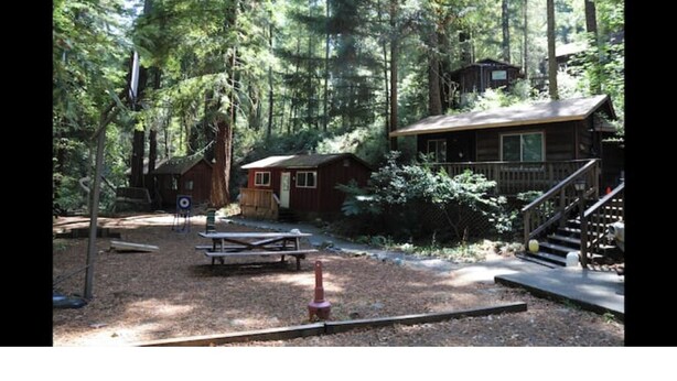 Eine Holzhütte mit einer Holzterrasse und einer Treppe, die zu einer Veranda führt.