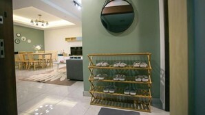 A hotel lobby with a shoe rack, a round mirror, and a dining area in the background. - Paradise Suite at KK Times Square, Beside Imago (Kota Kinabalu)