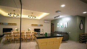 A modern kitchen with a central island, wooden chairs, and a dining area. - Paradise Suite at KK Times Square, Beside Imago (Kota Kinabalu)