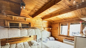 A cabin with bunk beds, wooden walls, and a window with a view. - Beautiful 1-bed Secluded Cabin, With bar & Fire (Godstone)