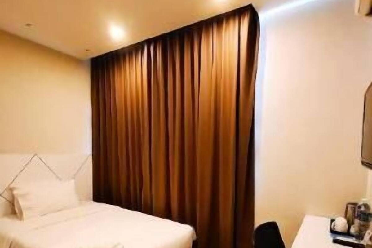 Quarto de hotel com uma cama, uma mesa e uma cadeira.