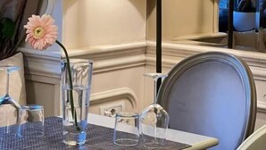 Een tafel met een lamp, een vaas met een bloem en een glas water.