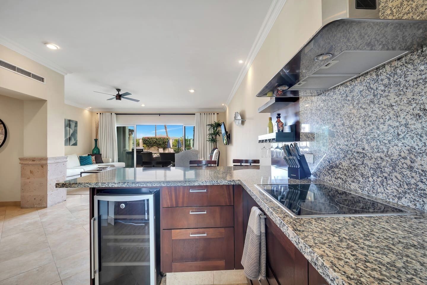 Una cocina moderna con encimeras de granito, horno integrado y zona de comedor con vistas.