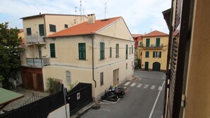 Un carrer estret amb edificis als dos costats, una moto aparcada i un pas de vianants.