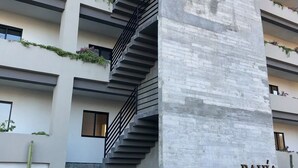 A modern building with a concrete pillar labeled "BAHIA" and a staircase leading to the entrance. - A privileged place in Los Cabos (Cabo San Lucas)