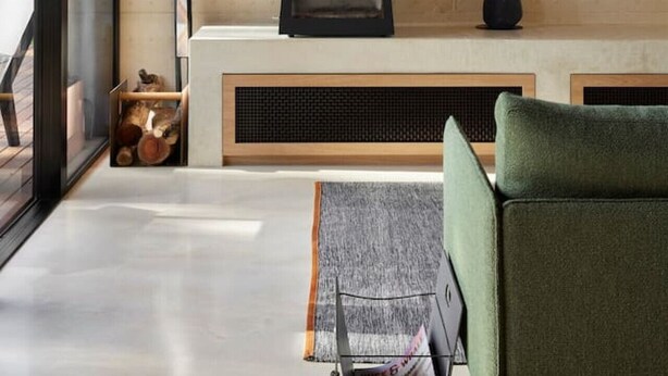 A modern interior with a wood-burning stove, a framed artwork, and a green sofa. - Ukiyo House “The Floating World” (Port Willunga)