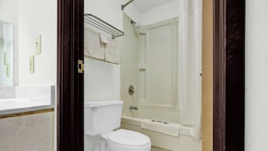 A bathroom with a toilet, a bathtub, and a shower curtain. - Brookville Inn By OYO Near Dayton International Airport (Brookville)