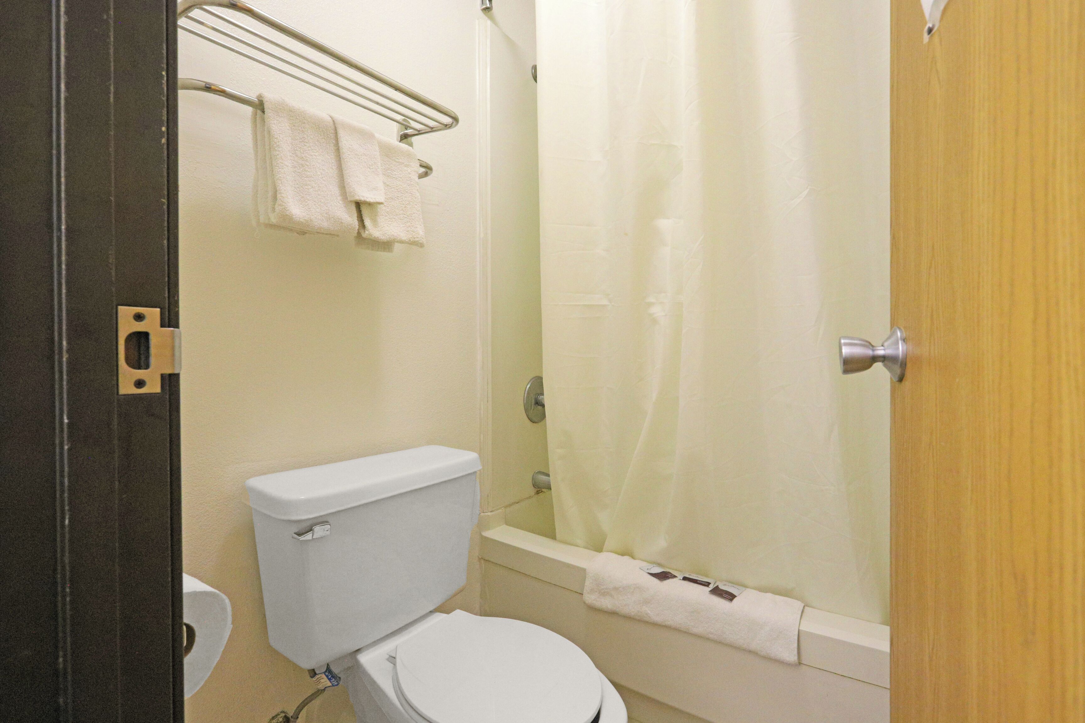 Un baño con inodoro, bañera y cortina de ducha.
