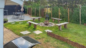 A patio area with a fire pit, stone benches, and a dining table with chairs. - Stunning home in Hemmet with sauna (Hemmet)