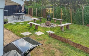 A patio area with a fire pit, stone benches, and a dining table with chairs. - Stunning home in Hemmet with sauna (Hemmet)