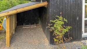 A wooden structure with a gravel driveway and a black exterior wall. - Stunning home in Hemmet with sauna (Hemmet)