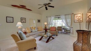 A living room with a sofa, armchair, coffee table, and a decorative vase. - Long-term discount! Spacious 3BR Home With Tropical Garden & Koi Pond in Lanai (Punta Gorda)