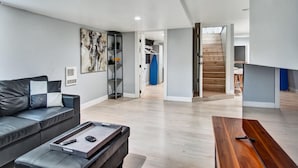 Una sala de estar moderna con un sofá, una mesa de centro y una obra de arte en la pared.