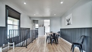 Un interior moderno con zona de comedor, una escalera y vistas a otra habitación.