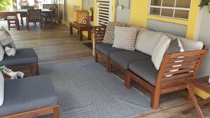 A wooden deck with a sofa, chairs, and a small table. - Charming Villa on Stunning Flamenco Beach Stylish & Confort steps to paradise🏝 (Culebra)