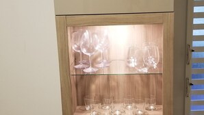 Un minibár con un estante de madera que exhibe varias copas de vino.