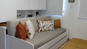 A modern living room with a grey sofa, a small table, and a white cabinet. - Charming Villa on Stunning Flamenco Beach Stylish & Confort steps to paradise🏝 (Culebra)