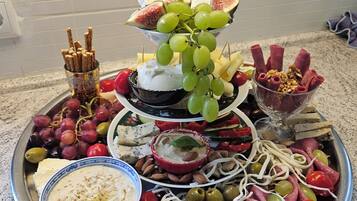 Un grand plateau à plusieurs niveaux, garni de différents fromages, de raisins, d’olives et de charcuteries.