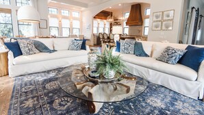 A spacious living room with a large sectional sofa, a glass coffee table, and a rustic rug. - Luxury in Old Seagrove  • Heated Pool  • Walk to Beach • Elevator • Widows Peak (Santa Rosa Beach)