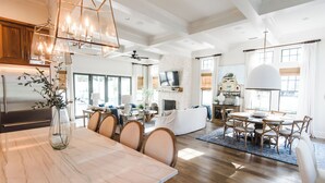 A spacious living area with a dining table, chairs, a sofa, and a television mounted on the wall. - Luxury in Old Seagrove  • Heated Pool  • Walk to Beach • Elevator • Widows Peak (Santa Rosa Beach)