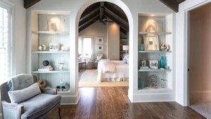 A bedroom with a wooden ceiling, a bed, and built-in shelving with decorative items. - Luxury in Old Seagrove  • Heated Pool  • Walk to Beach • Elevator • Widows Peak (Santa Rosa Beach)